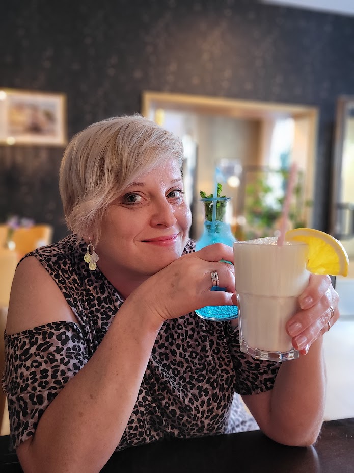 Katja Schneider an einem Tisch mit Getränken.